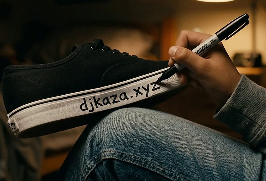 Writing djkaza.xyz on the side of a sneaker with a marker